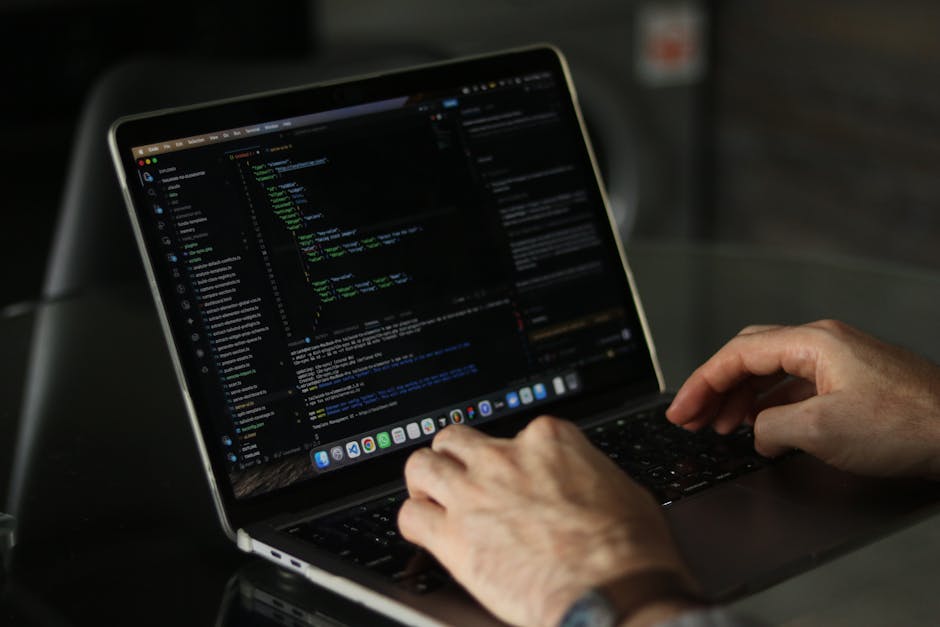A close-up view of a computer screen displaying lines of programming code with syntax highlighting, including elements such as colons, underscores, and keywords in various colors like green, blue, and